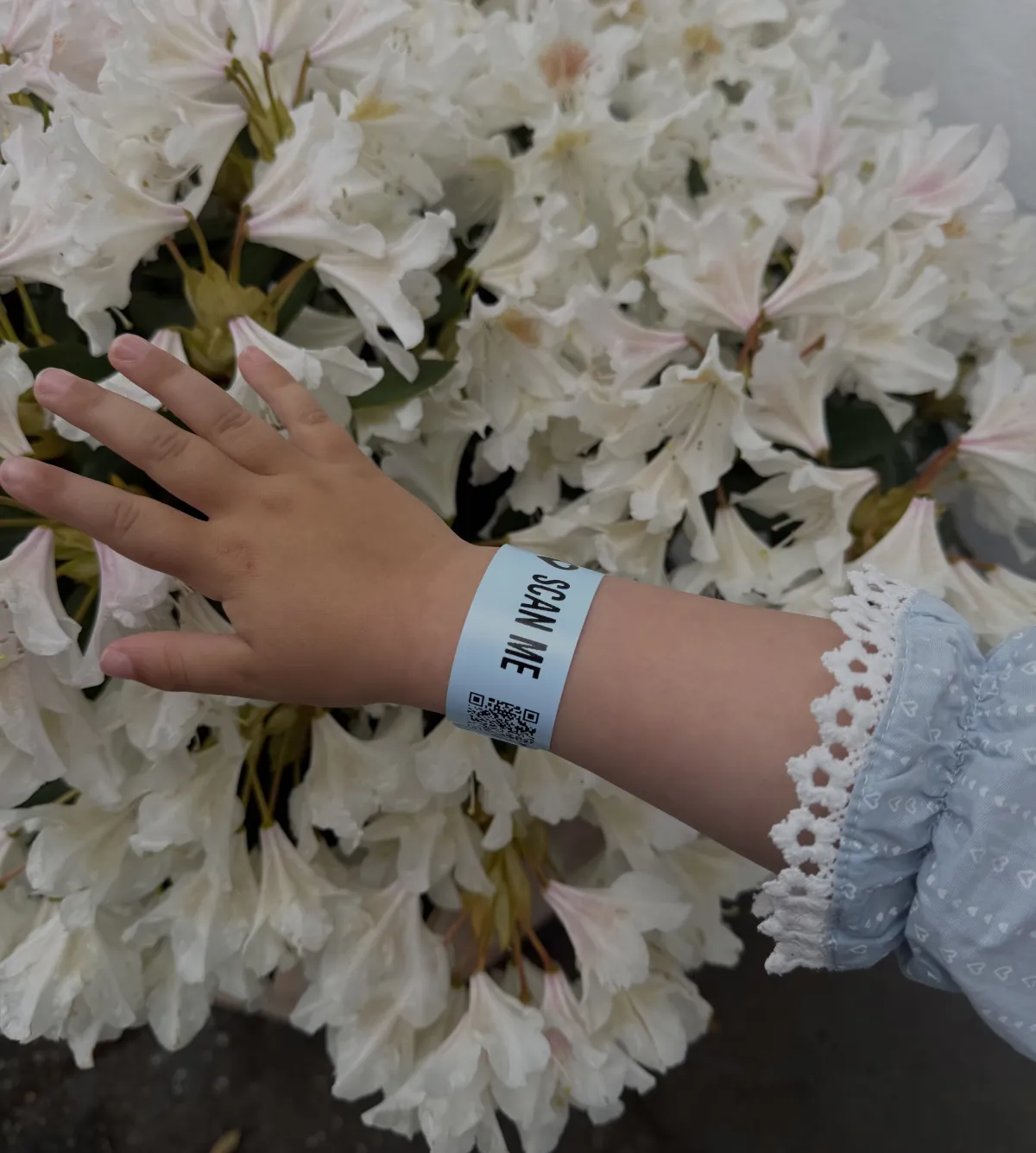Child wearing blue AYA wristband in flower field